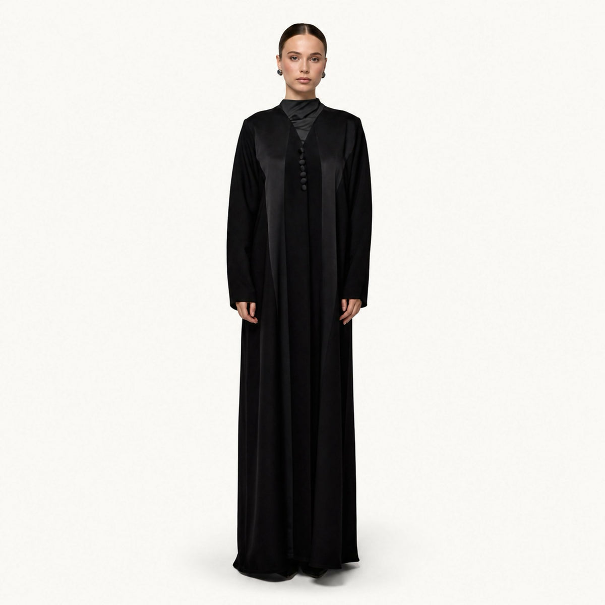 Elegant formal abaya with a satin panel at the chest and stand collar, finished with a row of decorative fabric-covered buttons down the front.