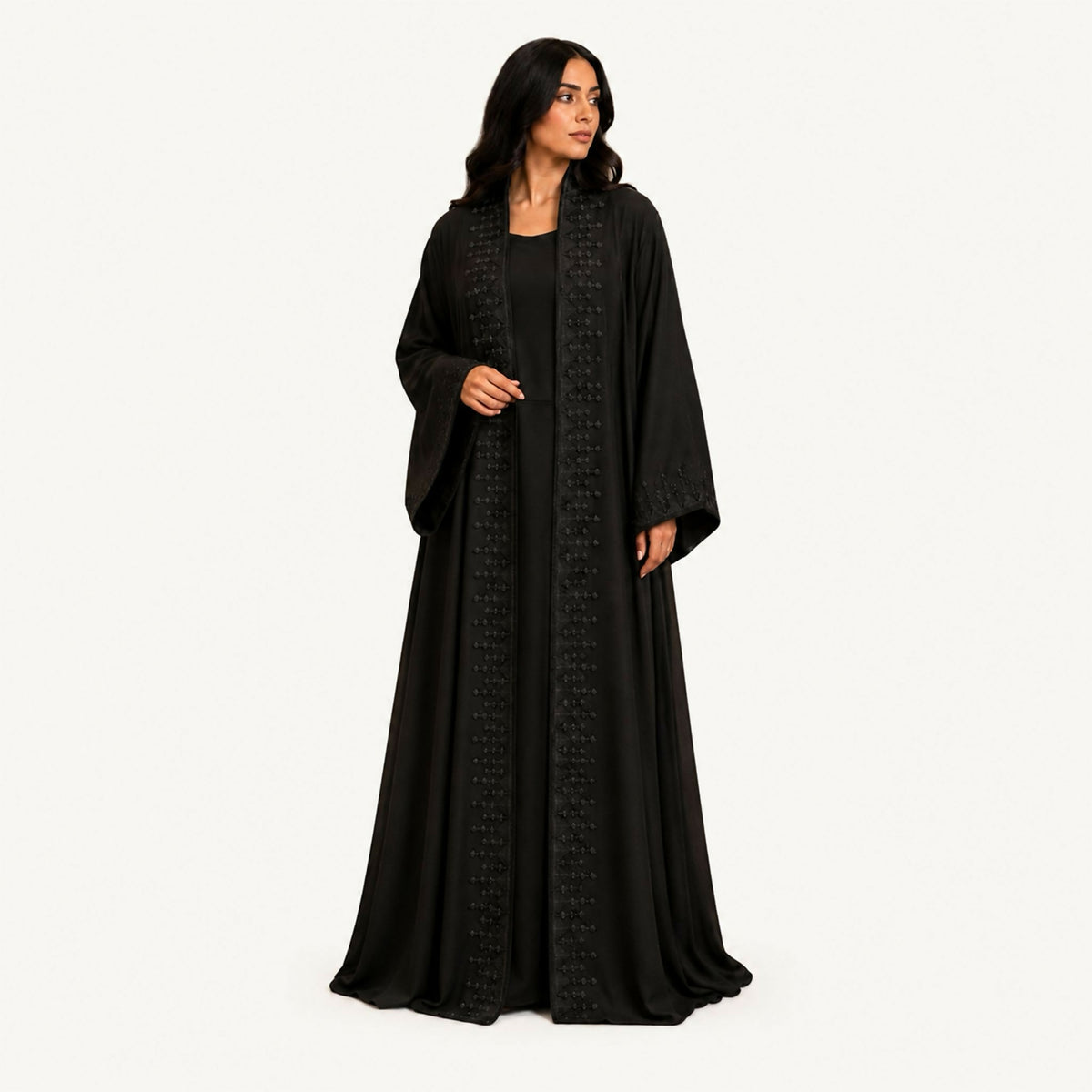 Black crepe abaya with a front panel featuring squares with navy embroidery and hand-perforation on the front and back. Fabric works for both summer and winter; hand wash or steam clean.