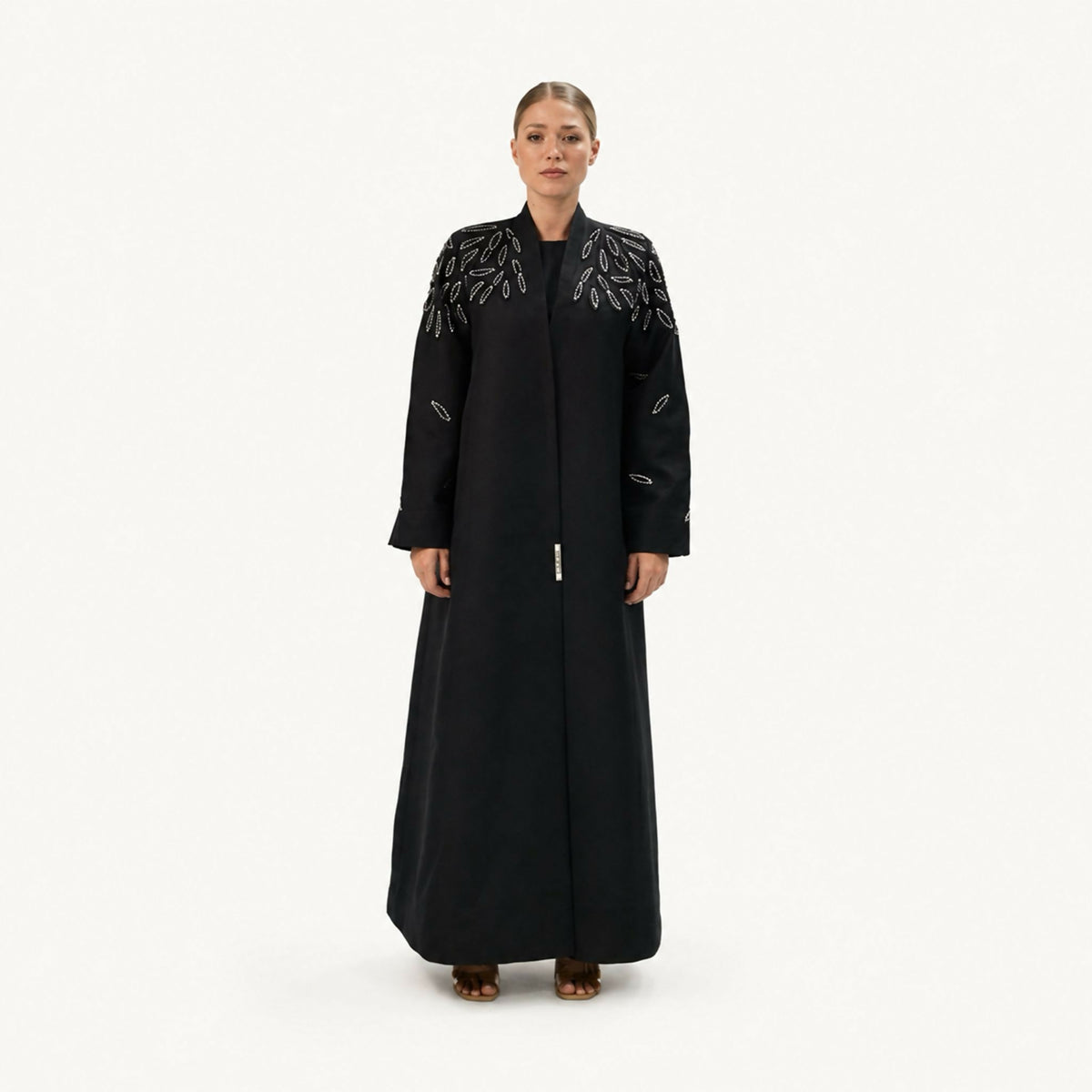 Sophisticated abaya featuring intricate 3D hand-embroidered silver floral detailing gracefully distributed throughout the design. Blending exceptional craftsmanship with contemporary elegance, it creates a refined look perfect for a variety of occasions