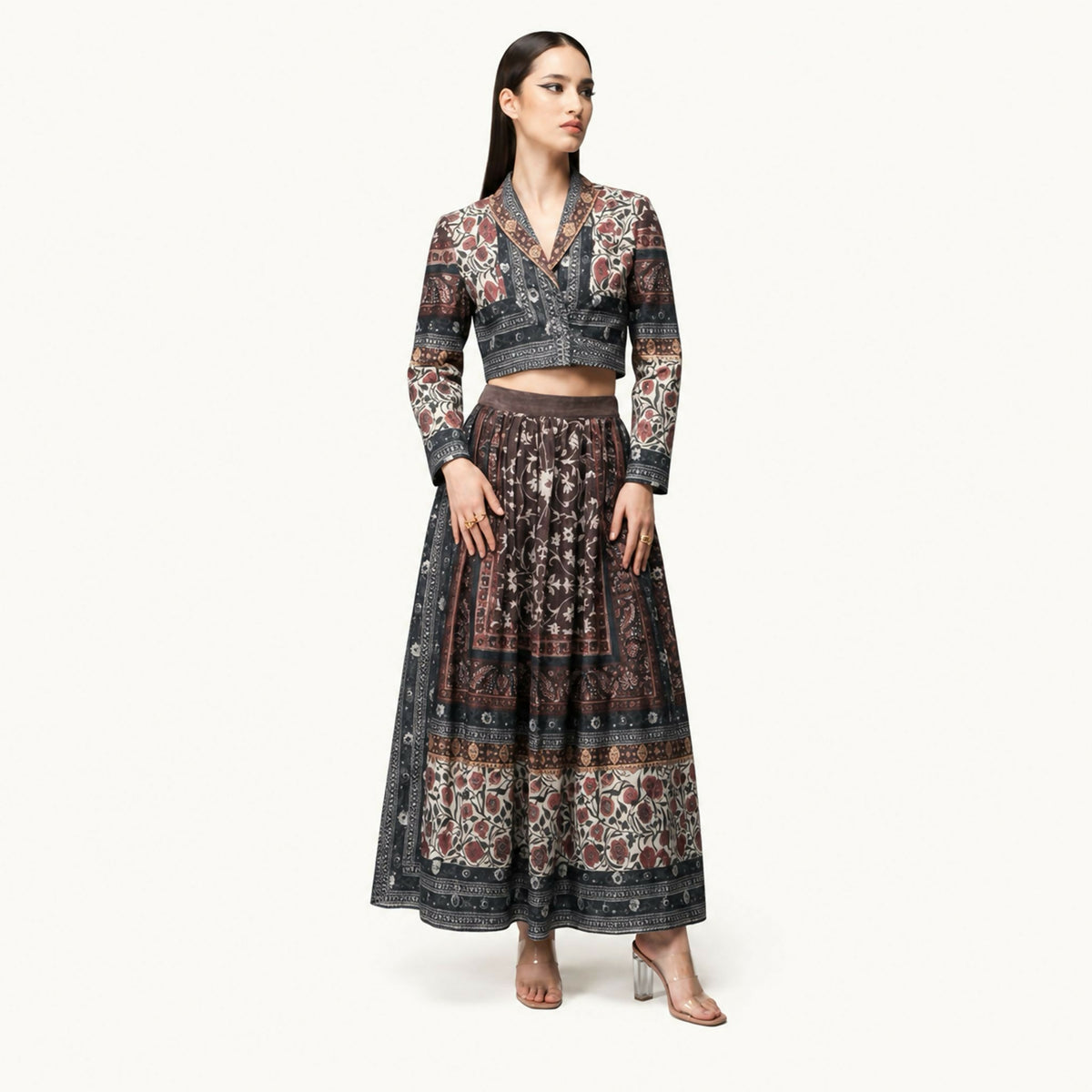 A three-piece set featuring a cropped jacket, a flowing maxi skirt, and a long outer layer with a back tie belt that forms an elegant bow, perfect for any occasion