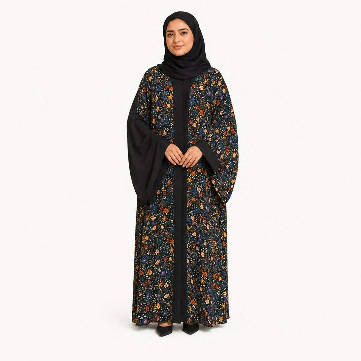Black abaya covered in a small-scale multicolor floral (ditsy) print, bordered by solid black center panel, sleeves, and hijab.